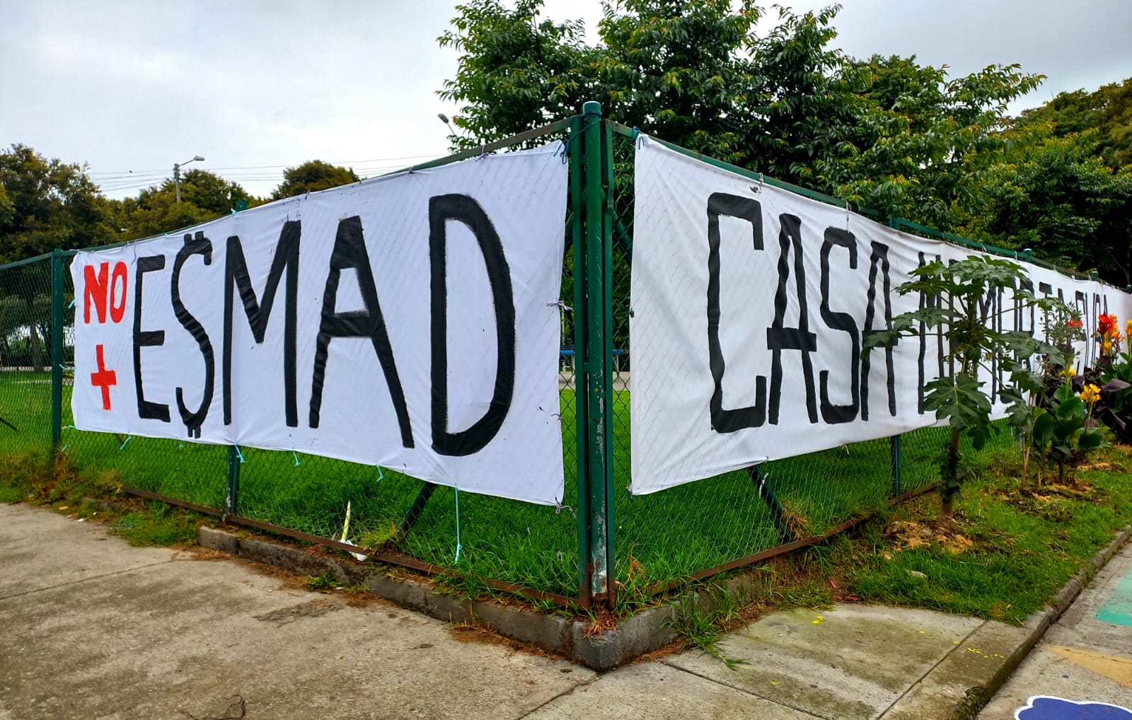 Personas tejiendo sobre una reja en un acto simbólico
